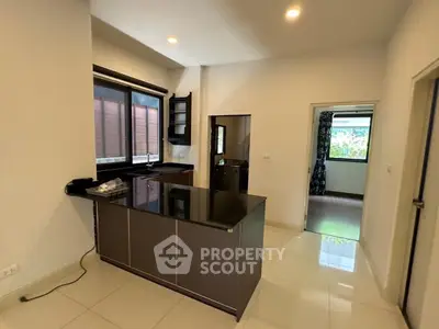 Modern kitchen with sleek black countertops and open layout in a bright, spacious apartment.