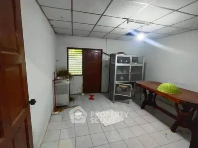 Spacious room with tiled floor, wooden table, and metal shelving unit, ideal for versatile use.