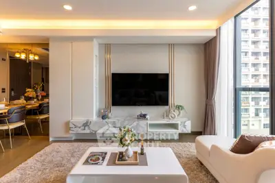 Luxurious modern living room with elegant decor and large window view in high-rise apartment.