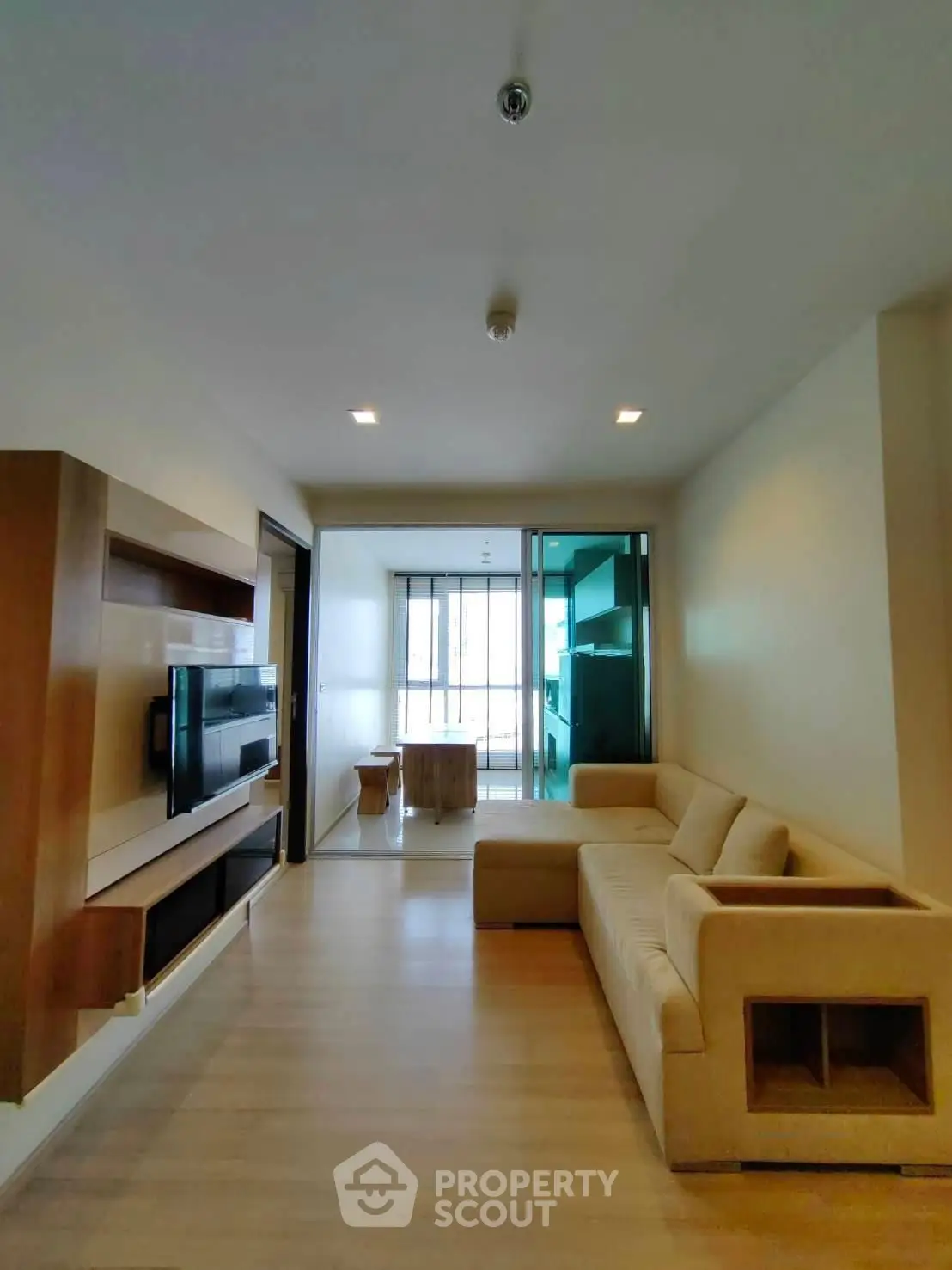 Spacious modern living room with cozy beige sofa and wall-mounted TV