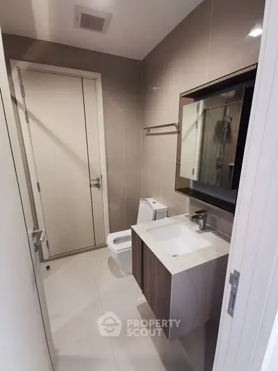 Modern bathroom with sleek fixtures and elegant design, featuring a stylish vanity and contemporary toilet.