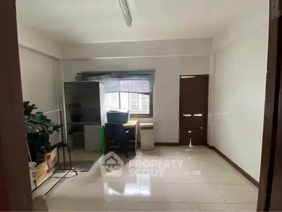 Spacious study room with natural light, tiled flooring, and minimalist decor, ideal for productivity.