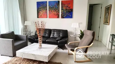 Spacious and modern living room with elegant marble coffee table, comfortable seating, and vibrant wall art creating a welcoming atmosphere.