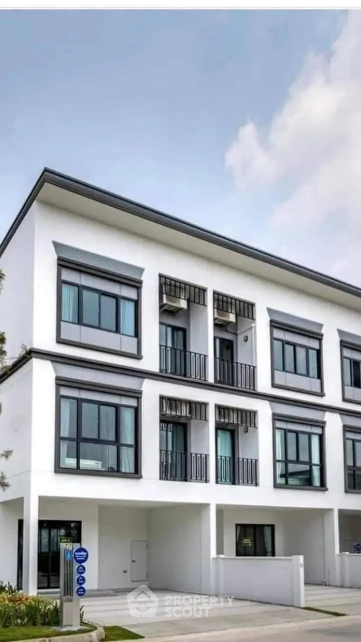 Modern three-story townhouse with sleek design and large windows in a serene neighborhood.