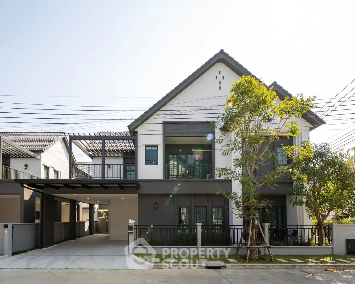 Modern two-story house with spacious driveway and lush greenery