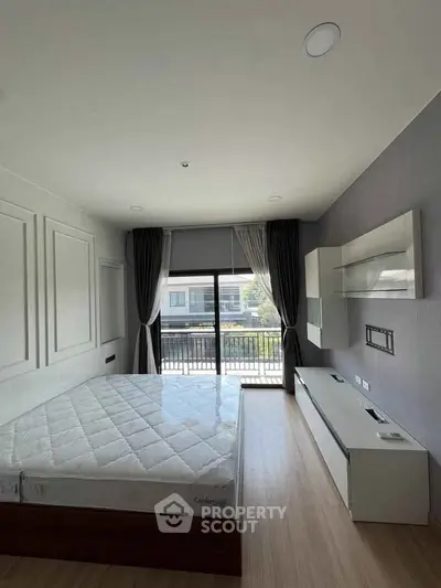 Spacious bedroom with large window and modern furnishings, perfect for comfort and relaxation.
