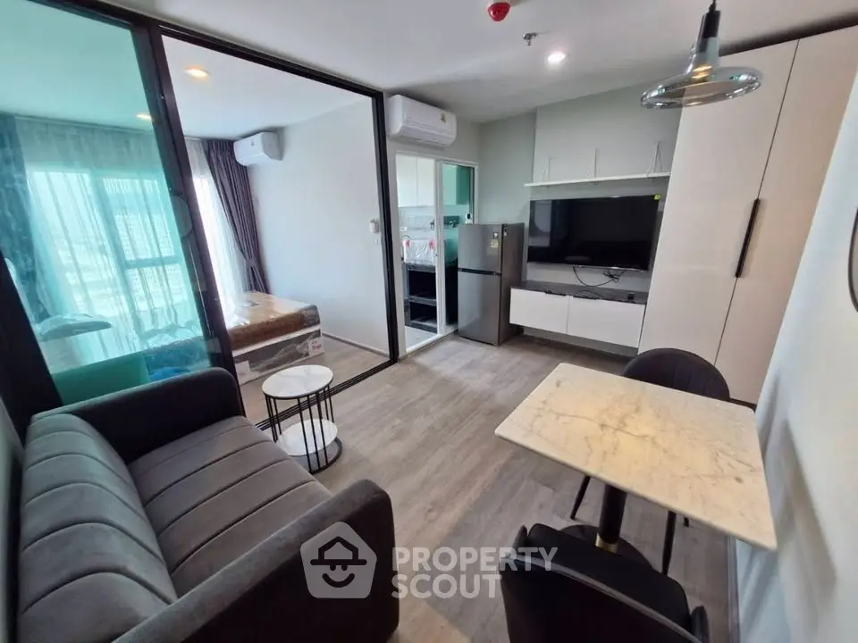 Modern open-plan living room with sleek furniture and kitchen in a stylish apartment.