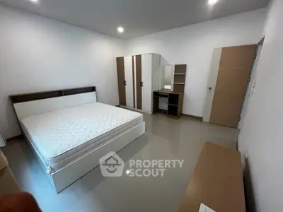 Spacious bedroom with modern furniture and ample storage space
