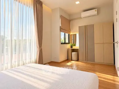 Bright and spacious bedroom with modern decor and large window for natural light.