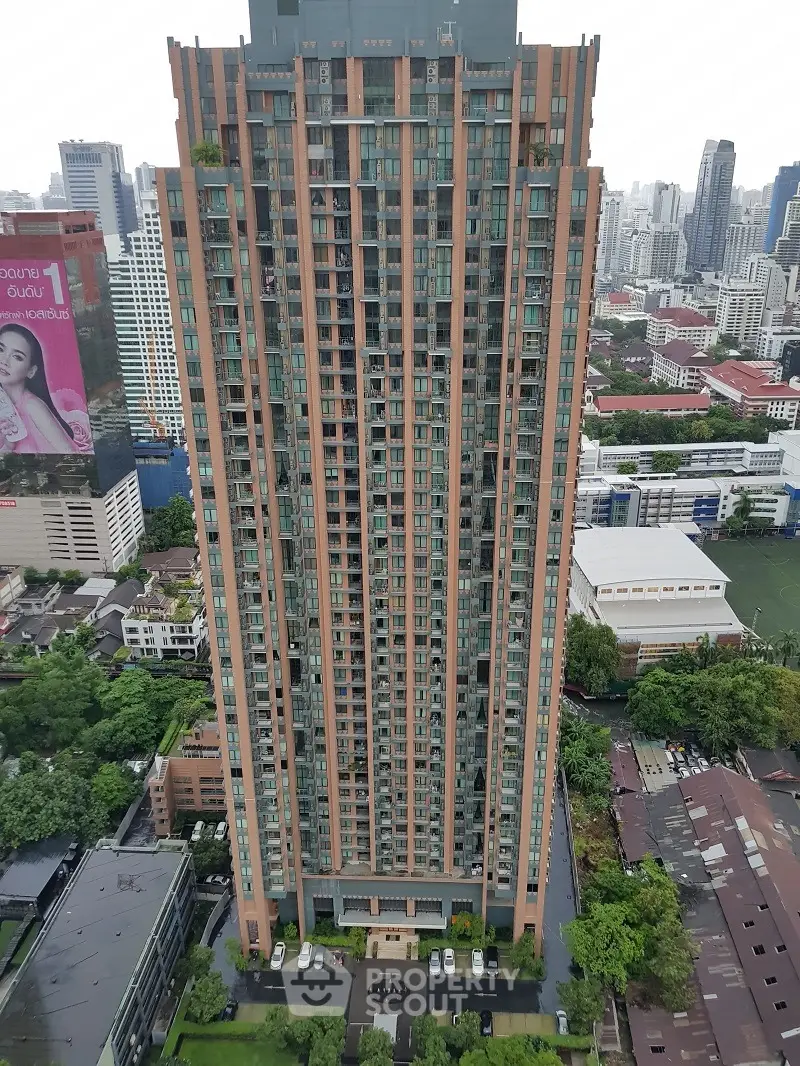 Stunning high-rise building with panoramic city views and lush greenery at the base.