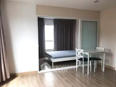 Spacious bedroom with wooden flooring and sliding glass doors in modern apartment.