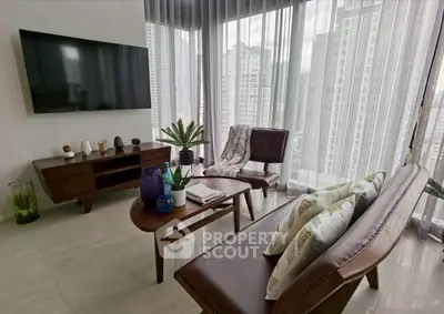 Modern living room with city view, sleek furniture, and large windows for natural light.