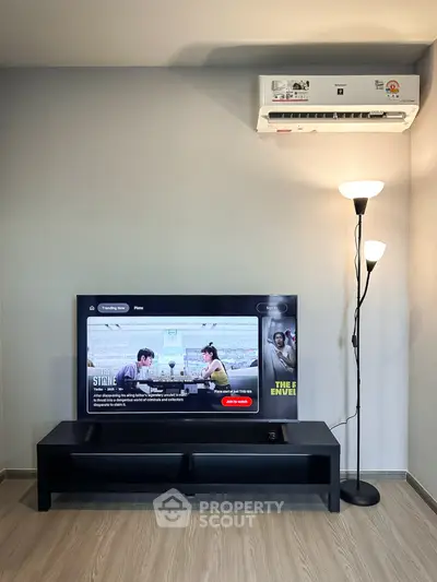 Modern living room with sleek TV setup and air conditioning, perfect for relaxation and entertainment.