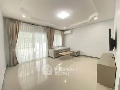 Spacious living room with modern decor and large windows
