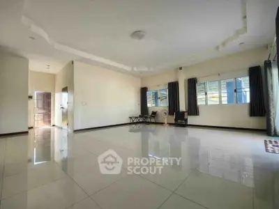 Spacious empty living room with large windows and glossy tiled floors