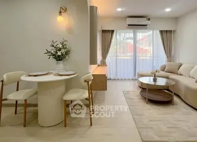 Elegant living room with modern decor, cozy seating, and natural light from large windows.