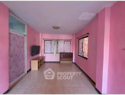 Spacious pink-walled room with tiled floor and large windows, ideal for customization.