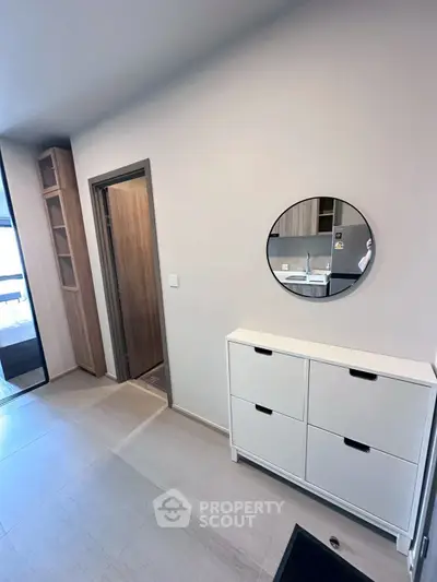 Modern apartment entrance with sleek storage and round mirror