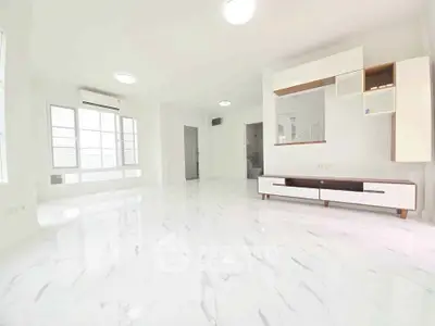 Spacious modern living room with marble flooring and sleek white furniture.