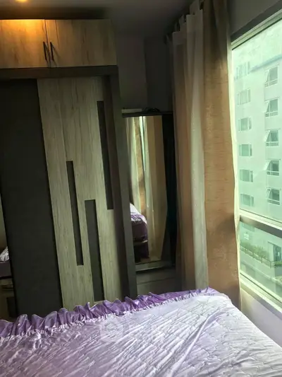 Cozy bedroom with modern wardrobe and large window offering natural light