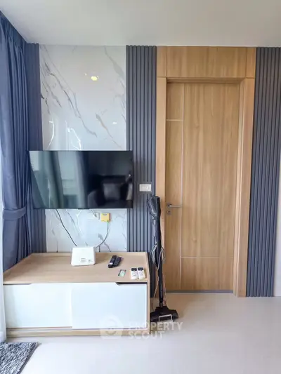 Modern living room with sleek TV setup and stylish wooden door