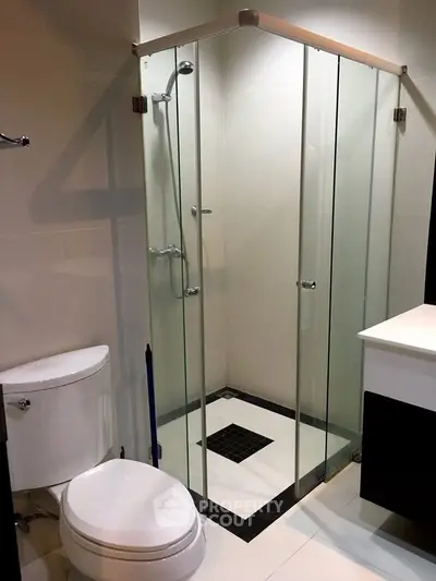 Modern bathroom with glass shower enclosure and sleek fixtures