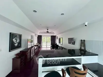 Spacious living room with modern decor and large windows opening to a balcony with a view.