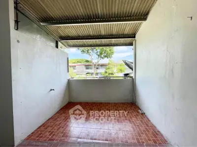 Spacious outdoor area with tiled flooring and open view, perfect for customization.