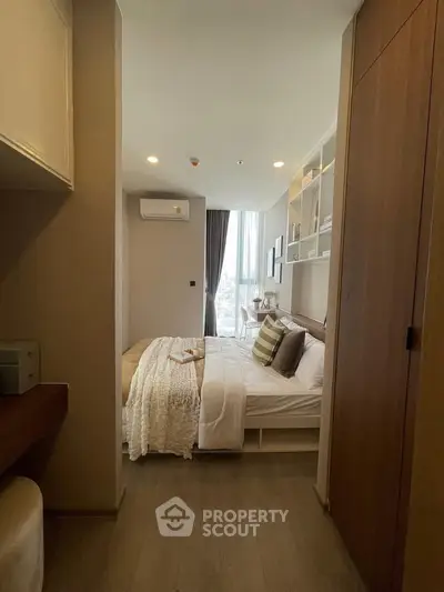 Cozy bedroom with modern decor and large window offering city view