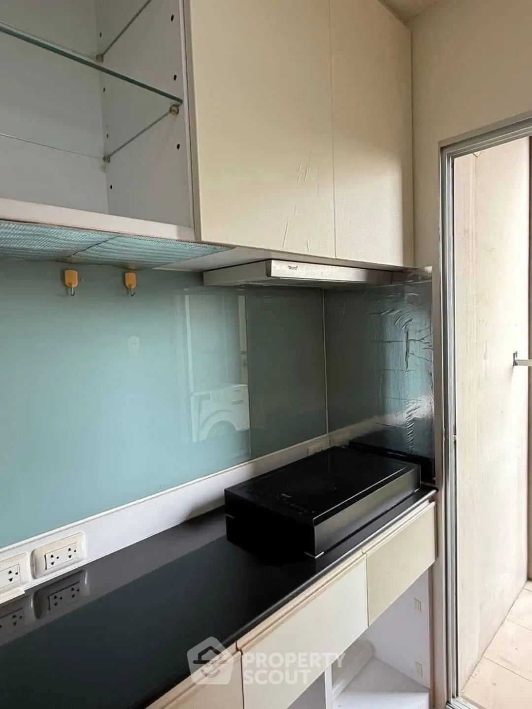 Modern kitchen with sleek black countertop and glass backsplash