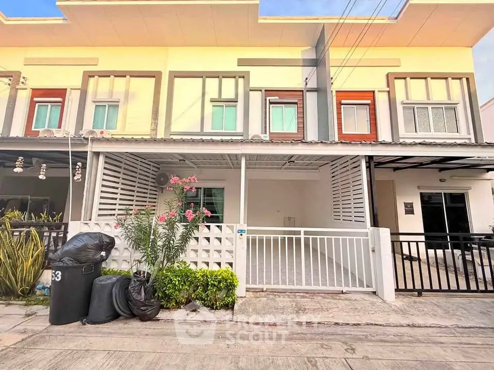Modern townhouse exterior with gated parking and landscaped front yard