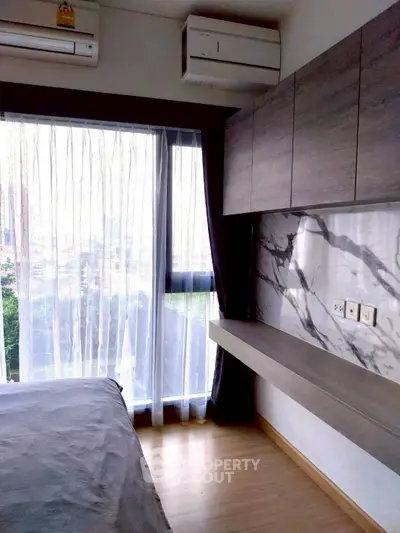 Modern bedroom with large window and stylish marble accent wall