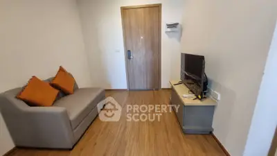 Cozy living room with modern sofa and flat-screen TV, perfect for relaxation.