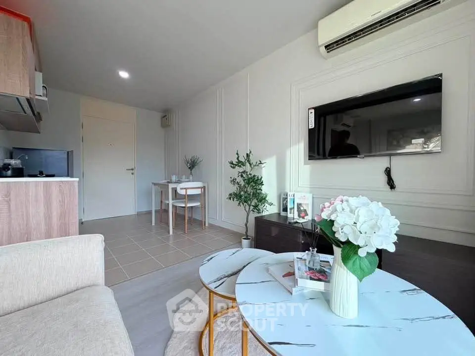 Modern living room with stylish decor, air conditioning, and open kitchen layout.