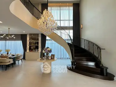 Luxurious living room with grand staircase and elegant chandelier