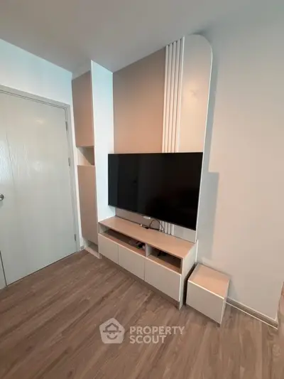Modern living room with sleek TV unit and stylish wooden flooring.