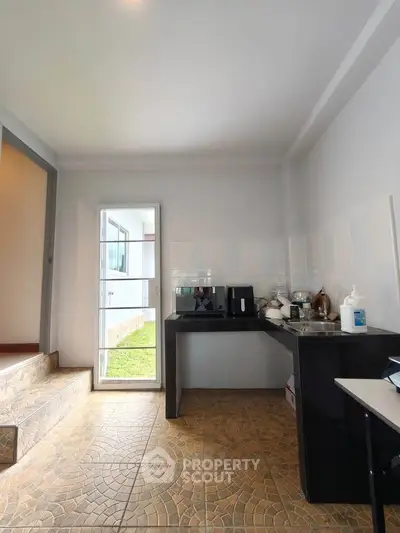 Spacious kitchen with modern appliances and open layout, featuring a bright window view.