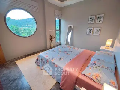 Charming bedroom with floral bedding and scenic round window view
