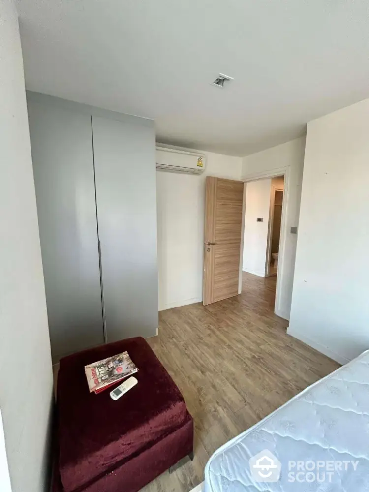 Cozy bedroom with wooden flooring and modern wardrobe in a stylish apartment.