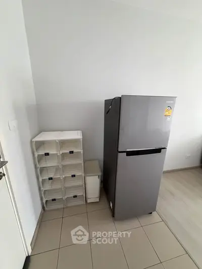 Modern kitchen corner with sleek refrigerator and organized storage boxes