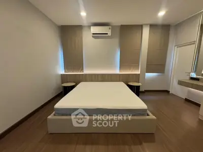 Spacious modern bedroom with minimalist design and ample natural light.