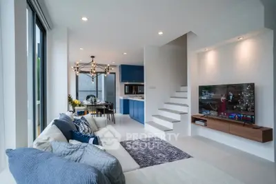 Modern open-plan living room with stylish decor and staircase in luxury home
