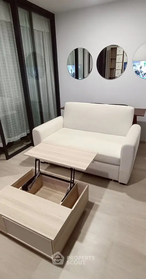 Modern living room with white sofa and multifunctional coffee table in stylish apartment.