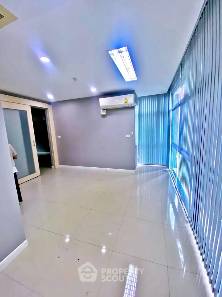 Spacious modern living room with large windows and air conditioning