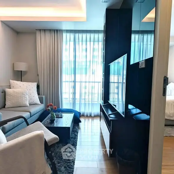 Modern living room with elegant decor and large windows offering natural light.