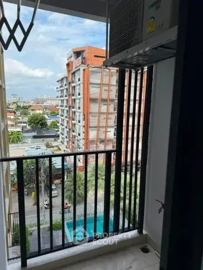 Urban balcony view with modern building and cityscape in the background.