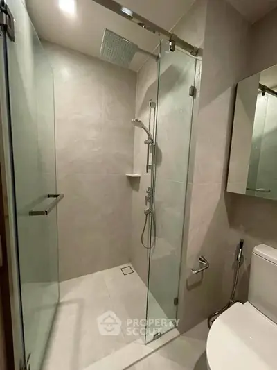 Modern bathroom with glass shower enclosure and sleek fixtures in a contemporary home.