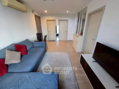 Modern living room with cozy sofa and sleek TV setup in stylish apartment.