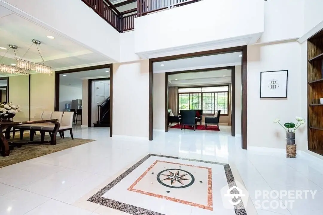 Elegant spacious living room with high ceilings, polished tile flooring, and a grand staircase leading to an open loft area, perfect for luxurious living.