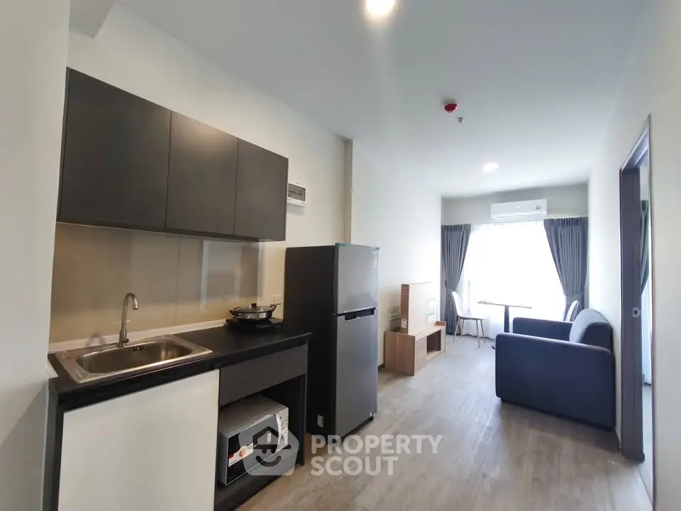 Modern open-layout kitchen and living room with sleek appliances and natural light.